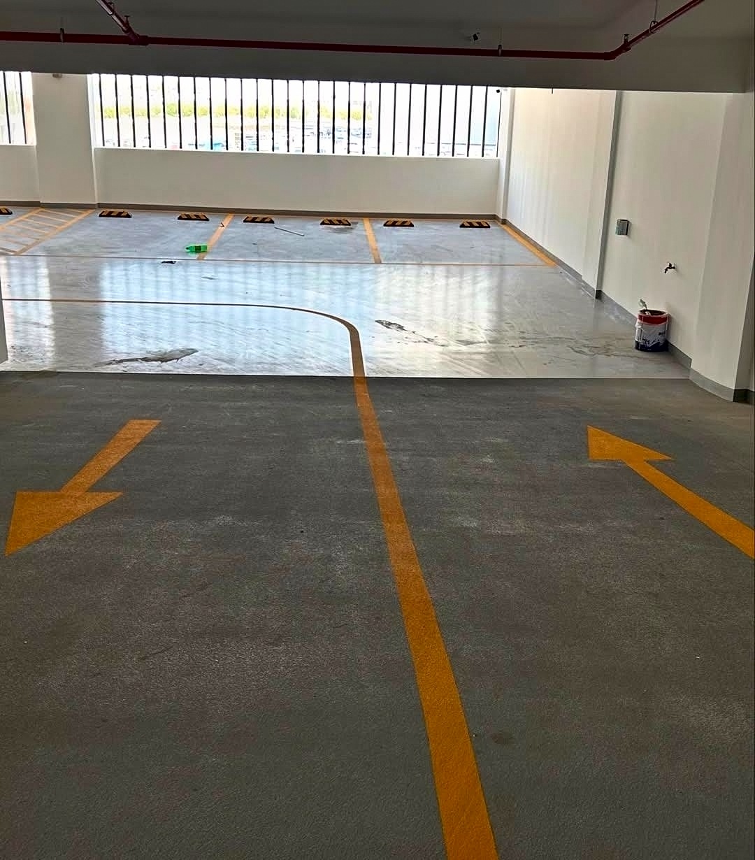 Car park lane with yellow direction arrows and floor coating in Bahrain