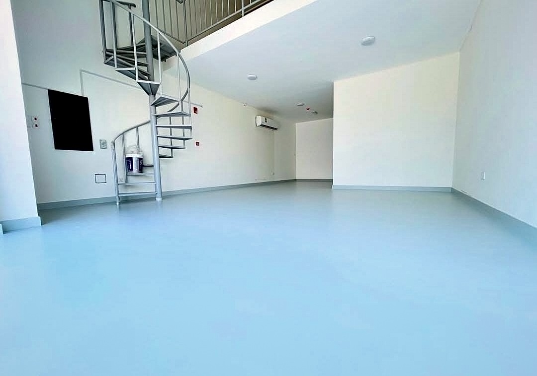 Smooth blue-grey resin floor finish in a loft unit in Bahrain